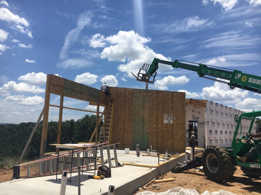 A wall panel lifted into place during the SIP installation